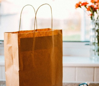 Kraft paper takeaway bag with rope handles, ready for packing.