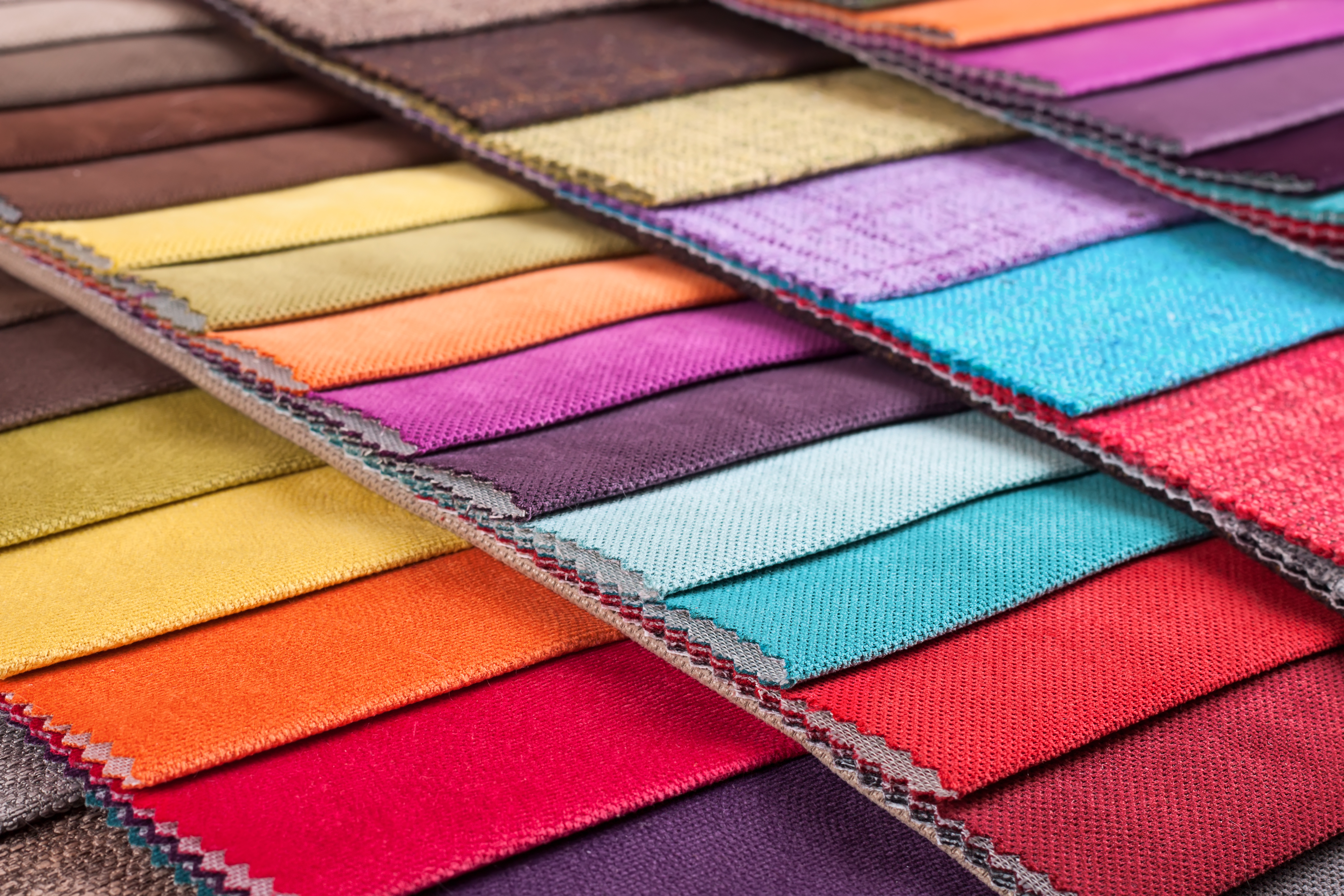 Fan of coloured non-woven fabric swatches.